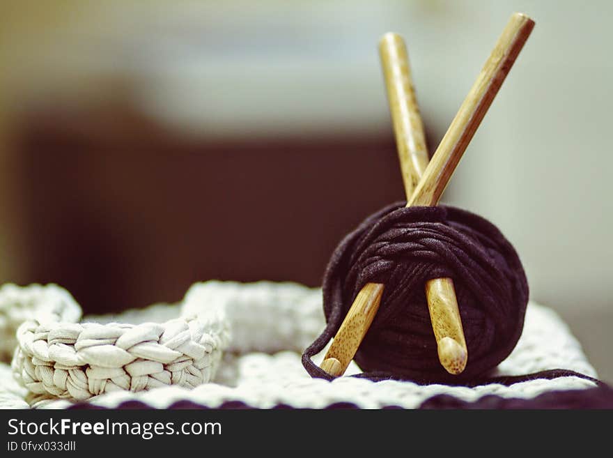 Brown Wooden Rod and Purple Yarn Ball Beside White Braided Cloth