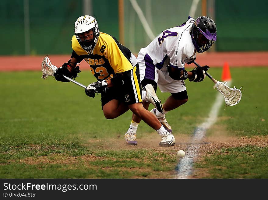 Man Wearing Yellow and Black Sport Jersey Holding Lacrosse Stick