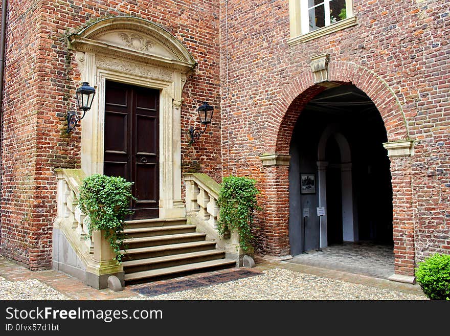 Stone stairs leading to wooden door outside brick building on sunny day. Stone stairs leading to wooden door outside brick building on sunny day.