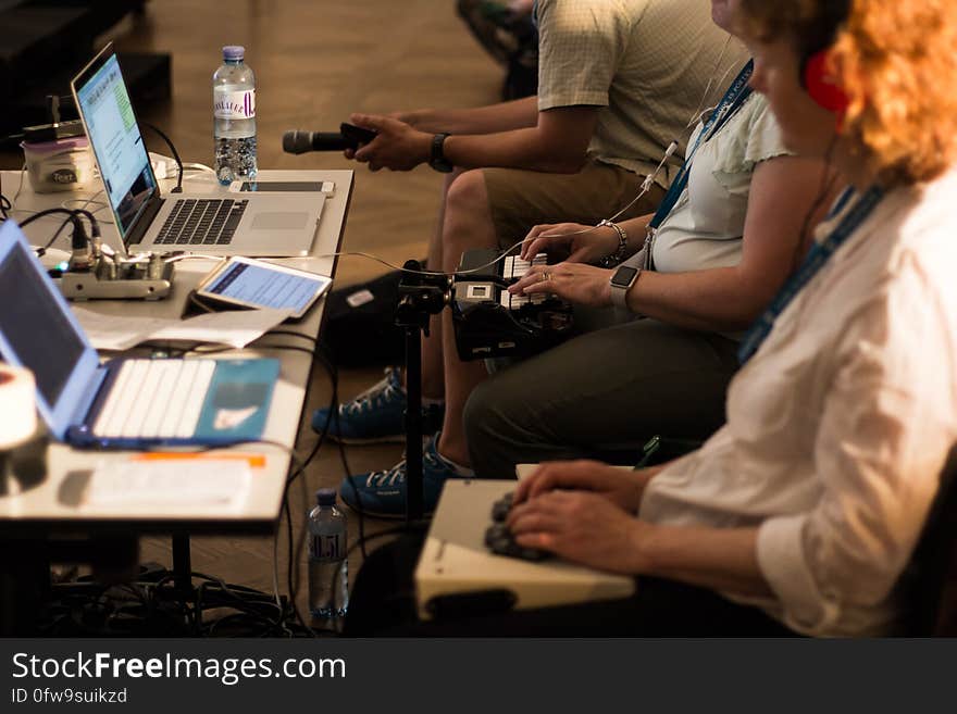 Workers sitting in front of row of laptop computers and equipment. Workers sitting in front of row of laptop computers and equipment.