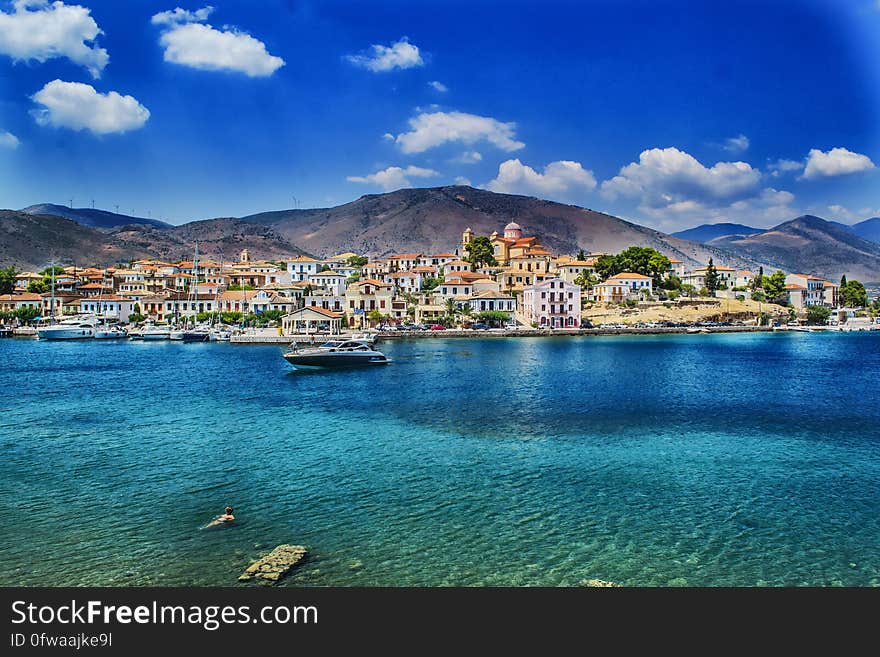 A view from the Greek archipelago with a city and blue sea. A view from the Greek archipelago with a city and blue sea.