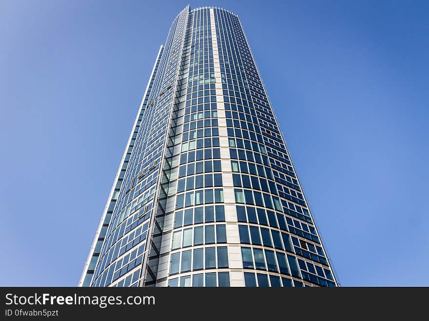 Facade of modern skyscraper against blue skies on sunny day.