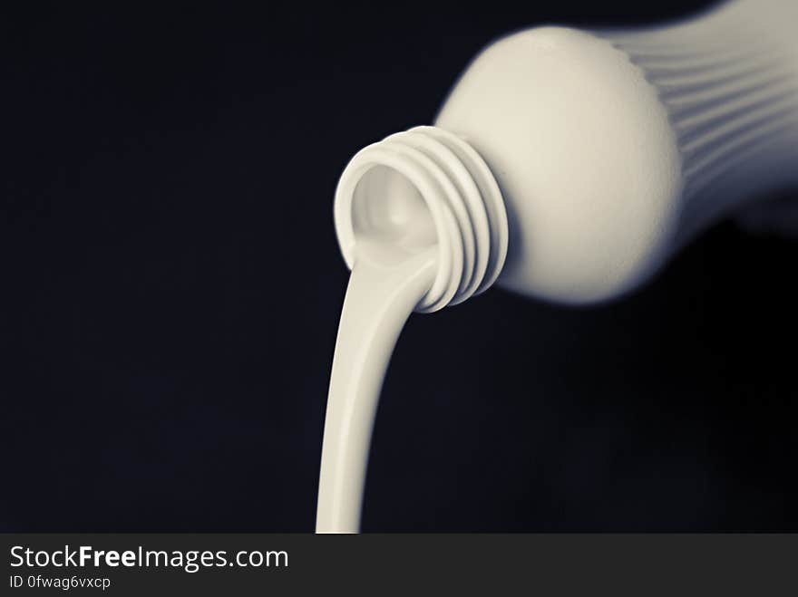 A bottle for drinkable yogurt with the contents pouring out. A bottle for drinkable yogurt with the contents pouring out.