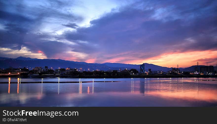 Blue Orange and White Sky over Water and Landscape