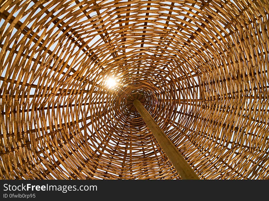 Abstract textures from wicker umbrella on wooden pole with sun shining through. Abstract textures from wicker umbrella on wooden pole with sun shining through.