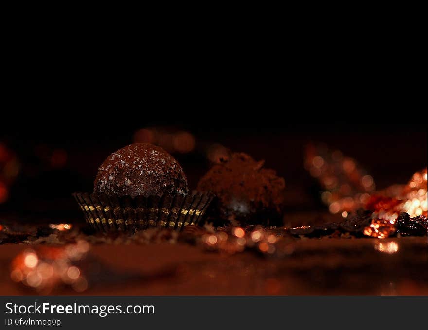 Some chocolate truffles on dark background.