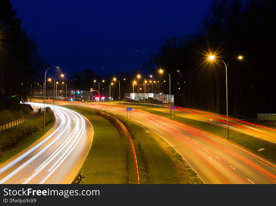 Blur of headlights and taillights on freeway illuminated with streetlamps at night. Blur of headlights and taillights on freeway illuminated with streetlamps at night.