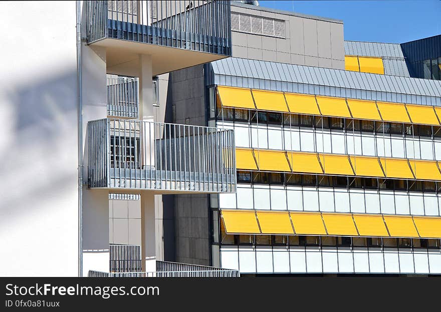 A contemporary apartment building with shades in front of the windows. A contemporary apartment building with shades in front of the windows.