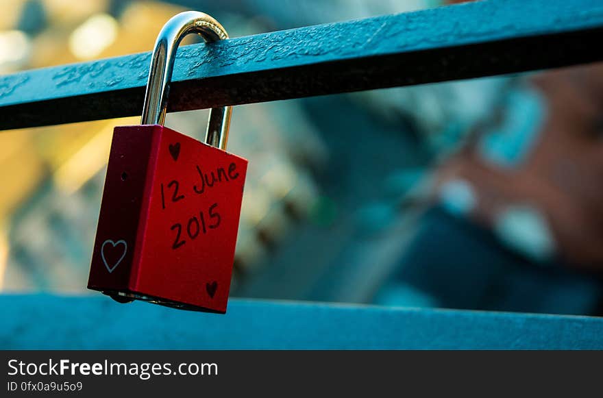 A single red love lock on a balcony.