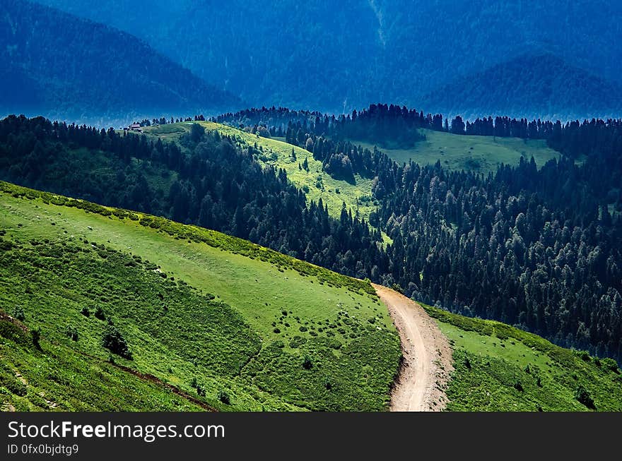 A landscape with green hills and a road passing through. A landscape with green hills and a road passing through.