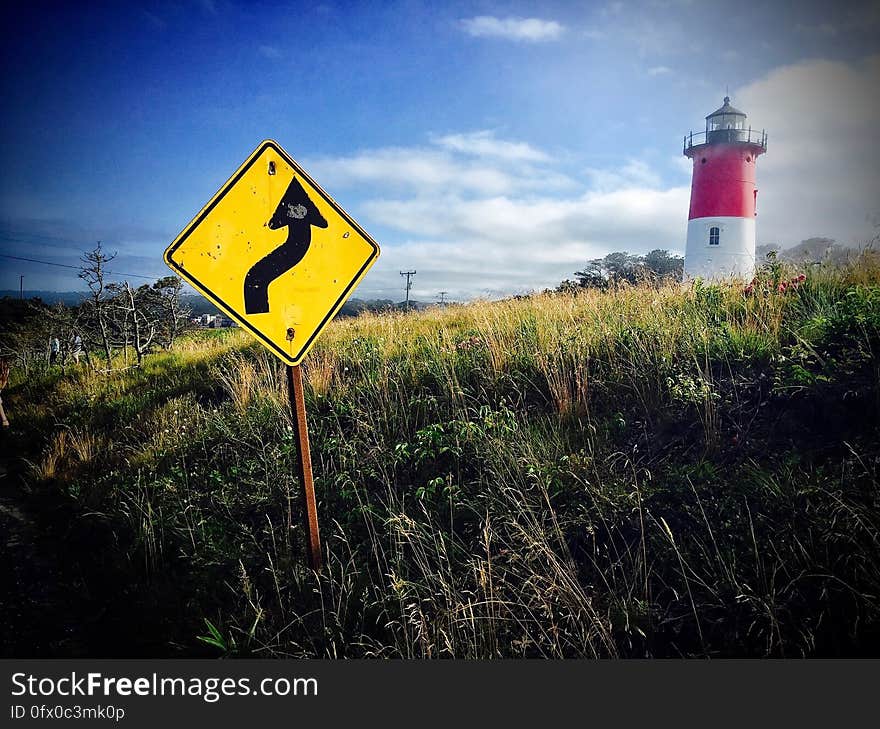 A lighthouse and a warning sign on the coast.