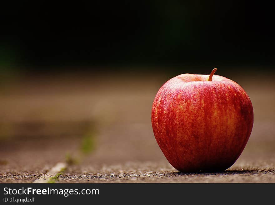 A close up of a red apple on table.