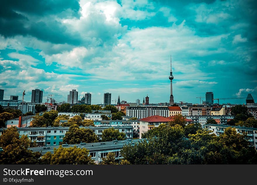 Urban skyline over rooftops with modern skyscrapers and tower against blue skies. Urban skyline over rooftops with modern skyscrapers and tower against blue skies.