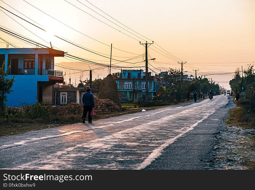 Man walking on street of rural town at sunset. Man walking on street of rural town at sunset.