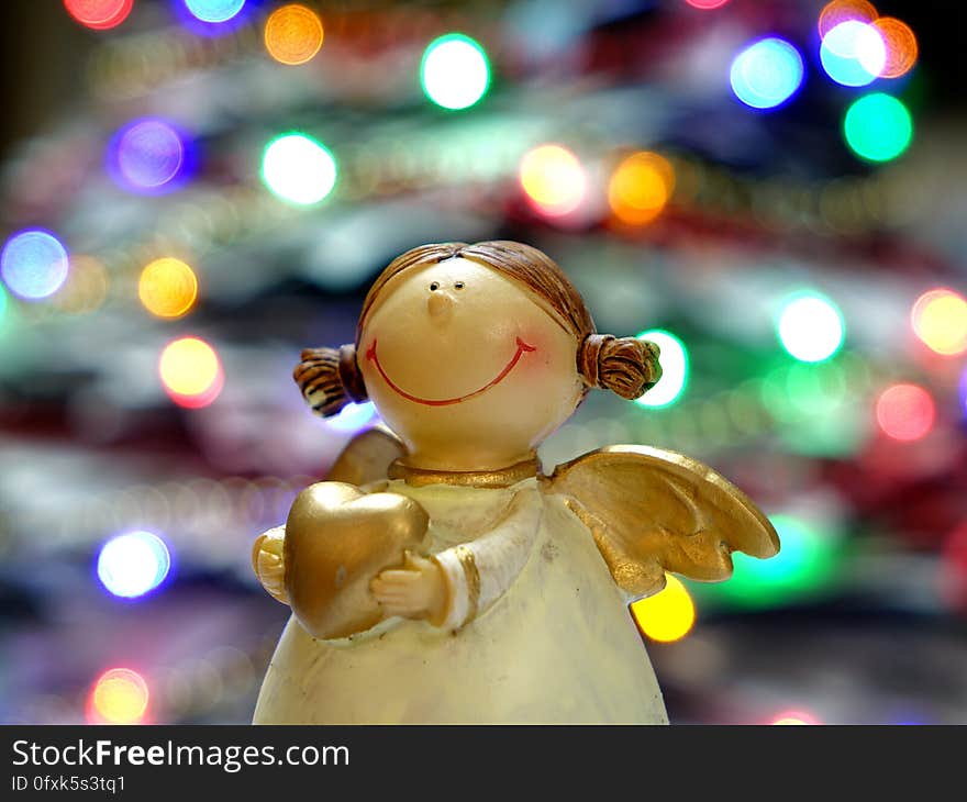 Bokeh Shot of White and Gold Ceramic Angel