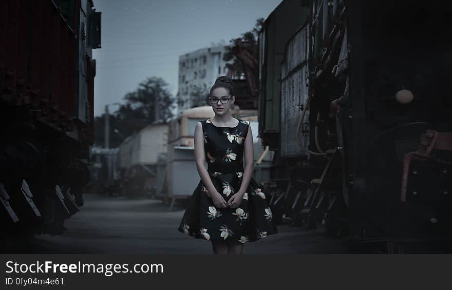 A woman wearing a black dress on a street. A woman wearing a black dress on a street.