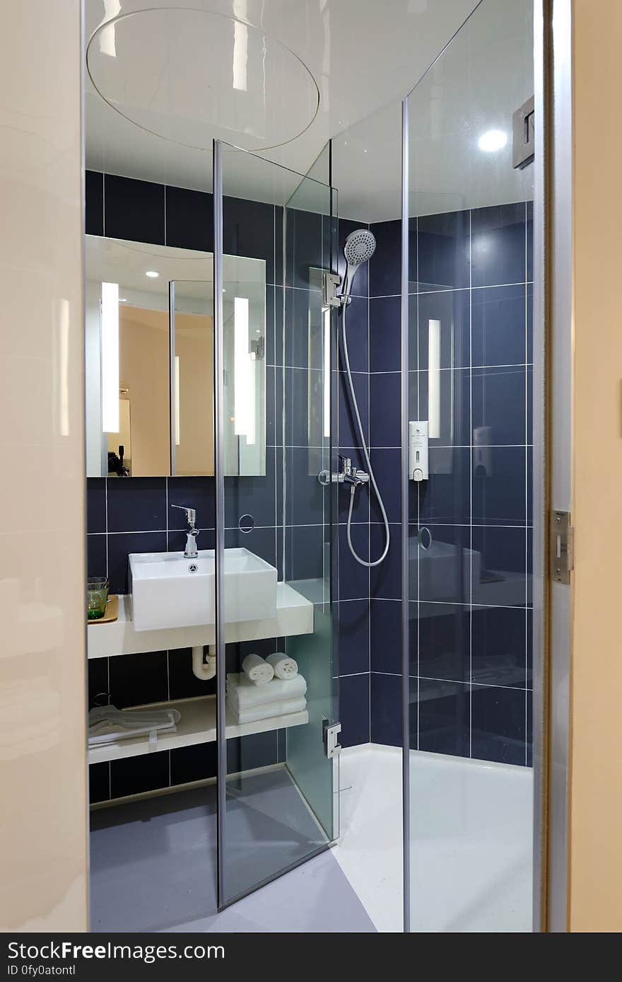 A modern bathroom with glass shower enclosure.