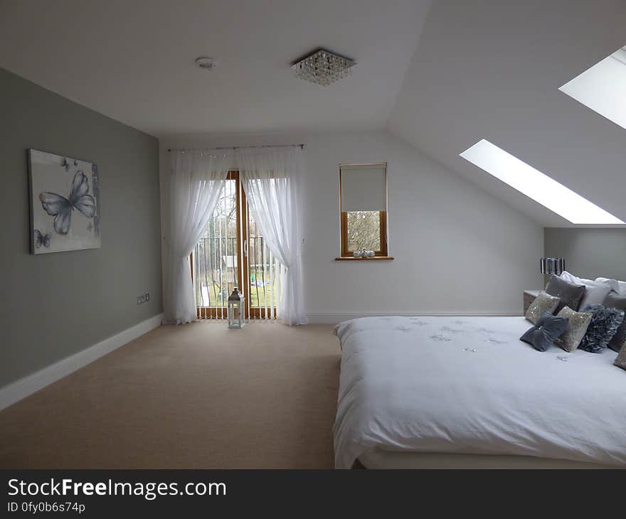 A modern bedroom with sloped ceiling.