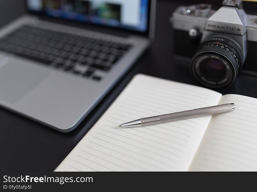 Black and Gray Dslr Camera Beside Macbook Pro