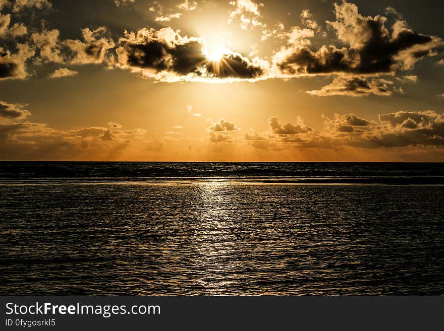 Sun Covered With Clouds Above Sea