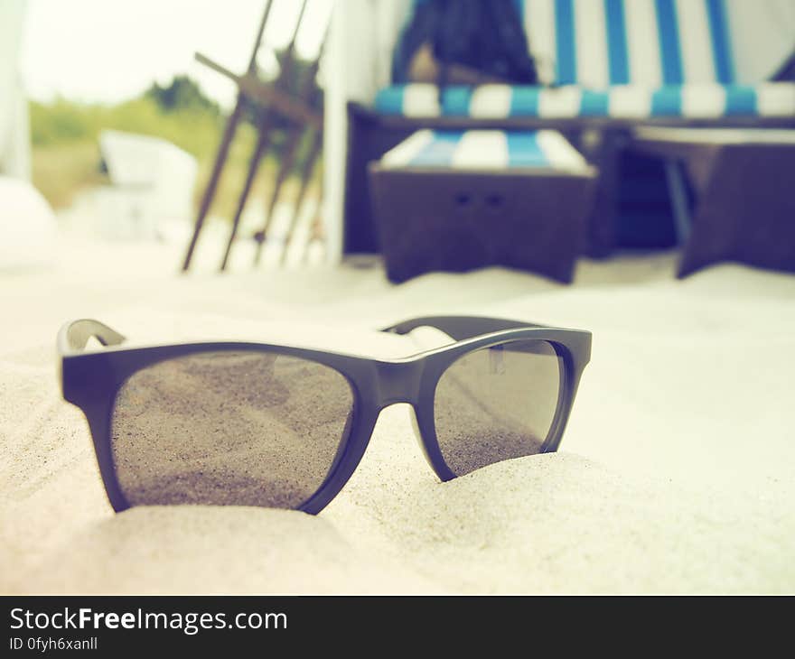 Black sunglasses on sandy beach in tropical resort. Black sunglasses on sandy beach in tropical resort.