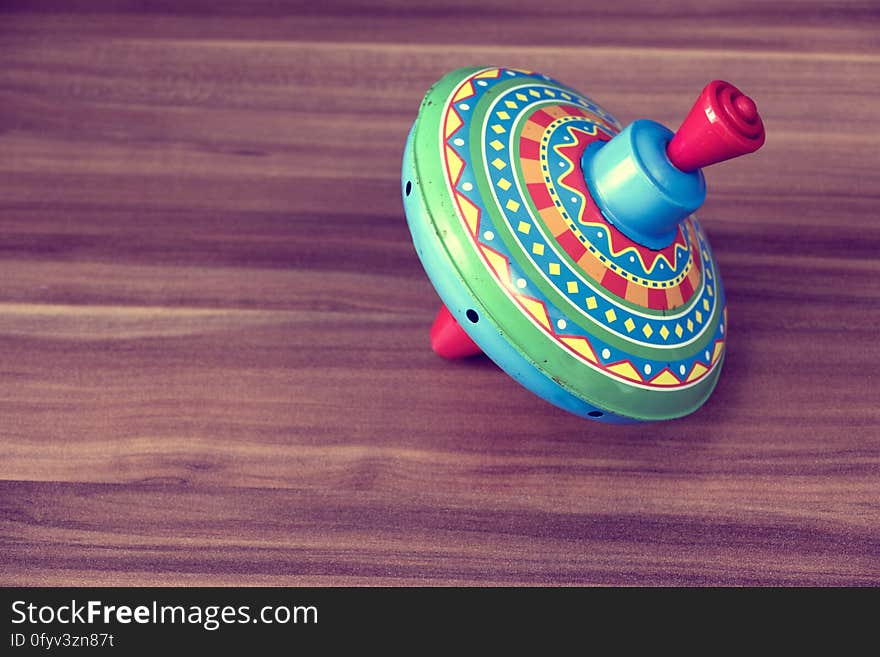 A colorful spinning top on a wooden background.