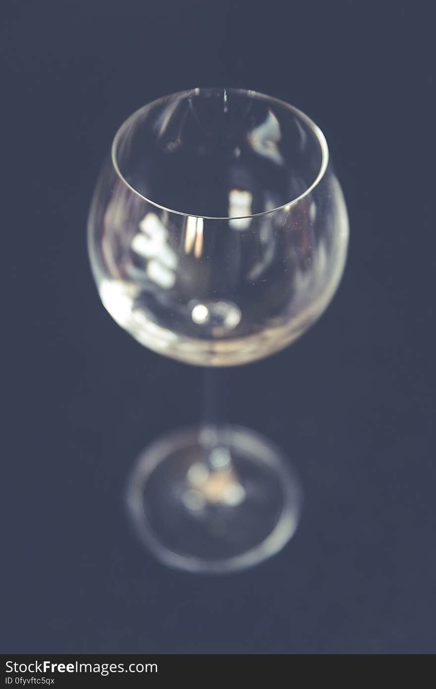 An empty wine glass on dark background.