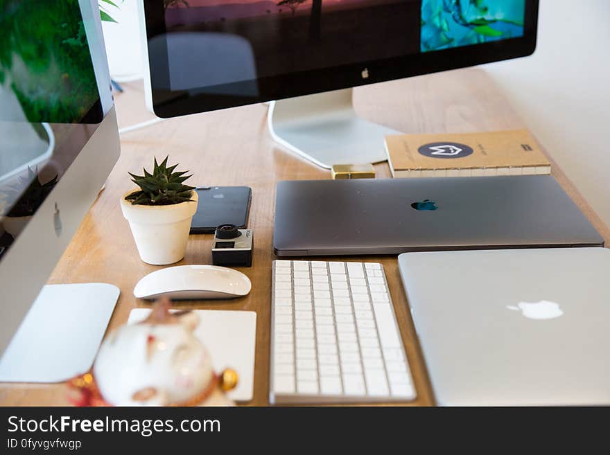 Apple desktop computers, laptop, tablet, keyboard and mouse on wooden desktop. Apple desktop computers, laptop, tablet, keyboard and mouse on wooden desktop.