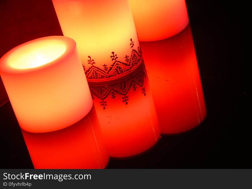 A reflecting table with three burning candles.