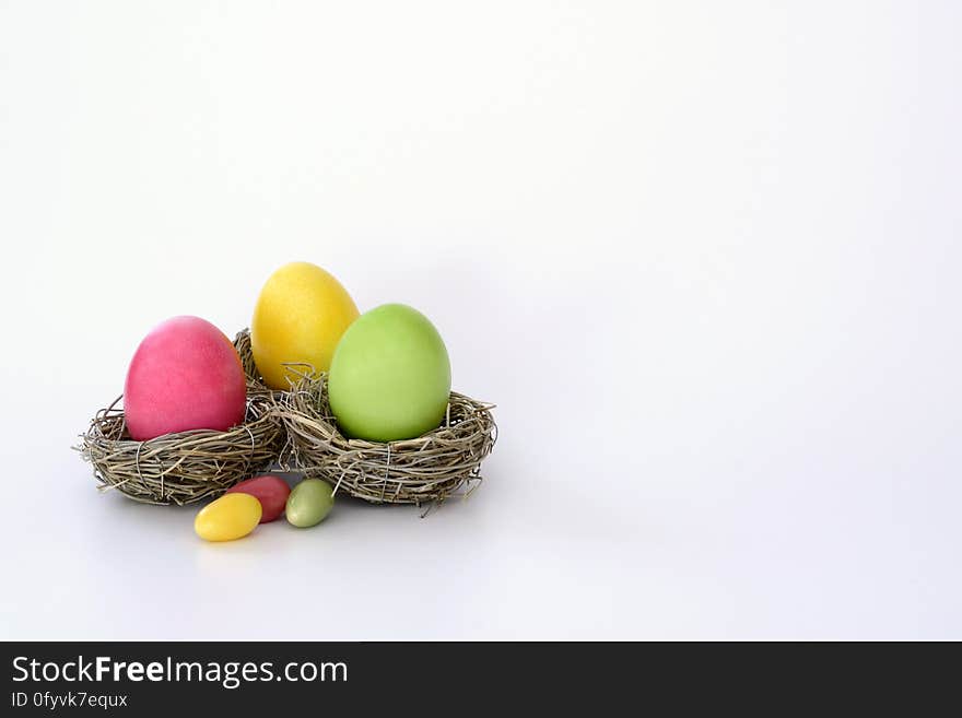 Colorful dyed Easter eggs in birds nests on white. Colorful dyed Easter eggs in birds nests on white.