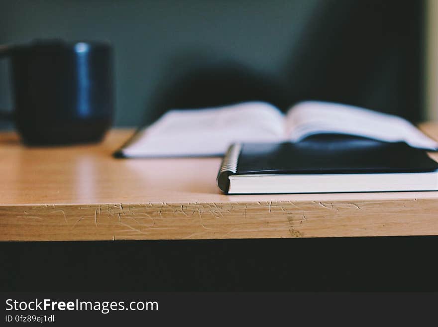 Black Notebook and Mug on Wooden Table