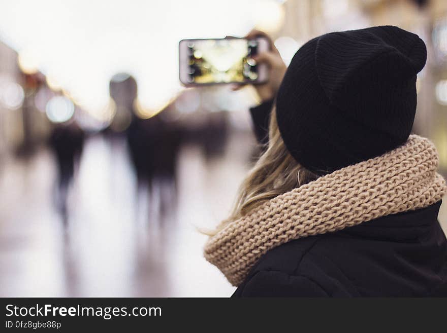 A woman snapping a photo with a smartphone camera. A woman snapping a photo with a smartphone camera.