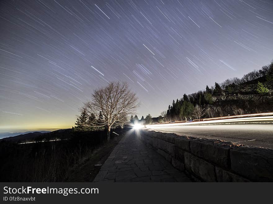 Star trails over country roadway along coastline at sunset. Star trails over country roadway along coastline at sunset.