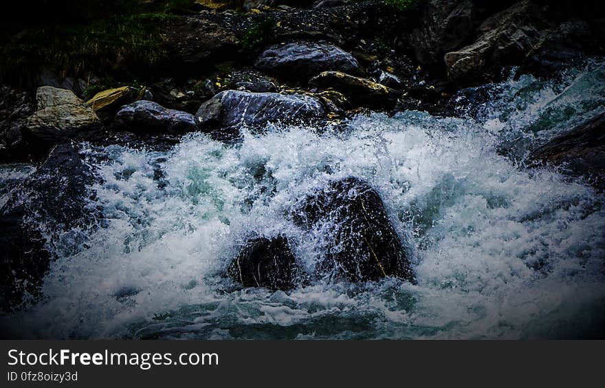 A view of a stream with water splashing on the rocks. A view of a stream with water splashing on the rocks.