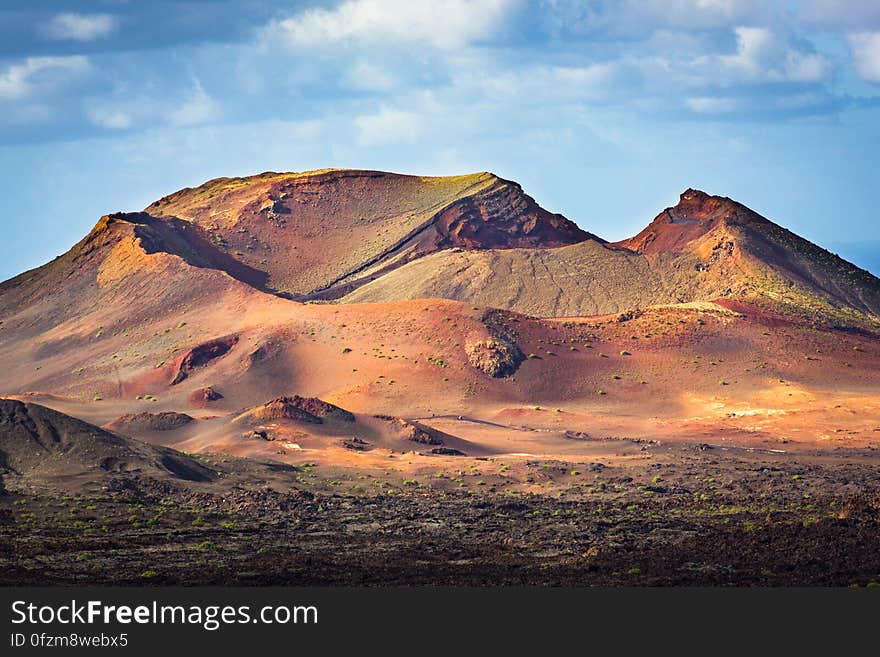 Desert landscape with sand dunes and rocky hills.