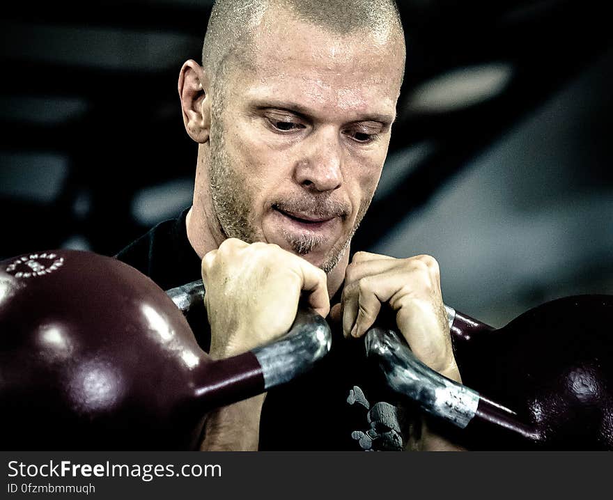 Portrait of man lifting weights in training indoors.