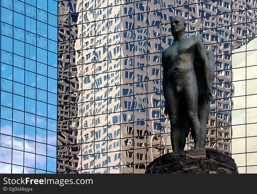 On the plaza is a mythic landscape: a cone of local rundle stone is a reference to the mountains; overscaled bronze ammonites a hidden landscape exposed. Standing on top, between earth and sky, are two bronze figures, back to back. Standing to the side, holding a fossil, is another figure â€“ his gaze distracted by the view of the sky. On the plaza is a mythic landscape: a cone of local rundle stone is a reference to the mountains; overscaled bronze ammonites a hidden landscape exposed. Standing on top, between earth and sky, are two bronze figures, back to back. Standing to the side, holding a fossil, is another figure â€“ his gaze distracted by the view of the sky.