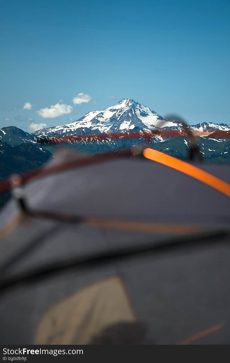 A close up of a tent with mountains in the background. A close up of a tent with mountains in the background.