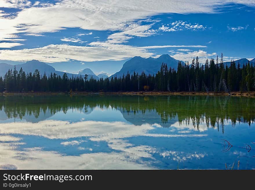 A lake reflecting forest, mountains and the sky. A lake reflecting forest, mountains and the sky.