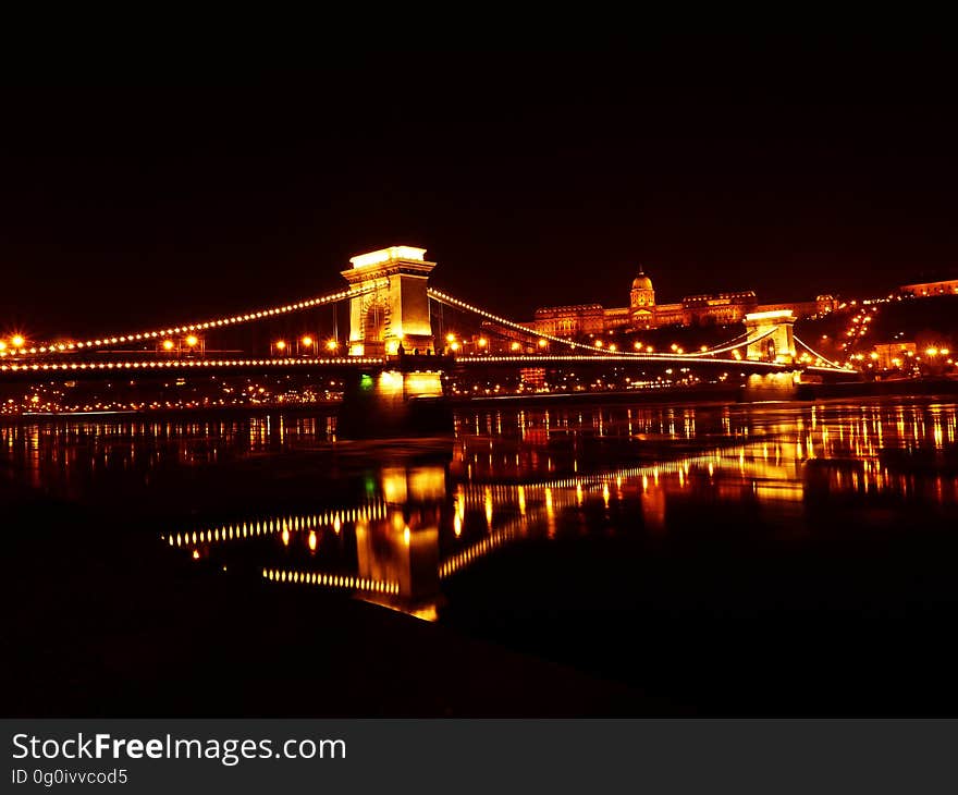 Illuminated Bridge over River at Night