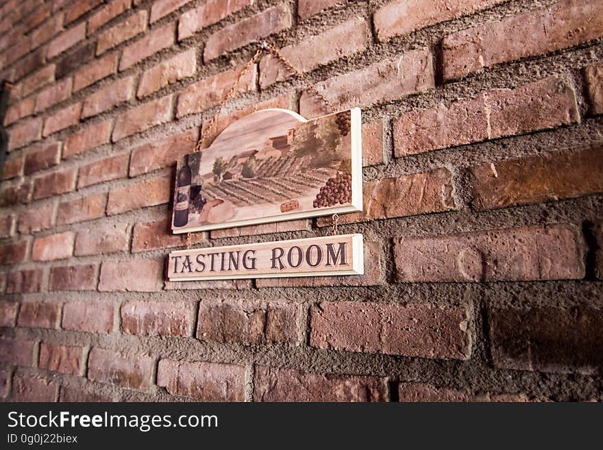 A brick wall with the sign for a tasting room.