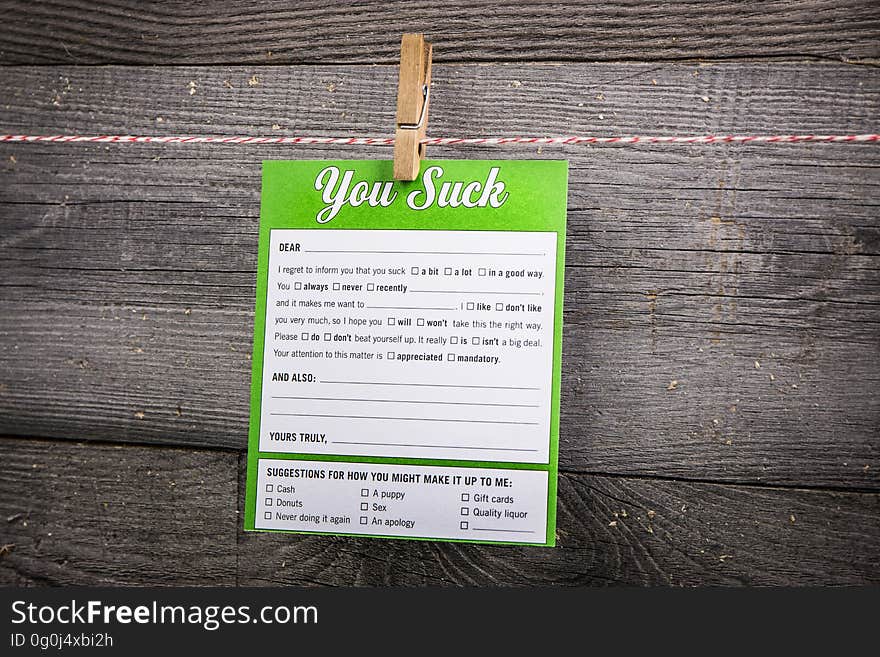 A "you suck" note on a wooden background.