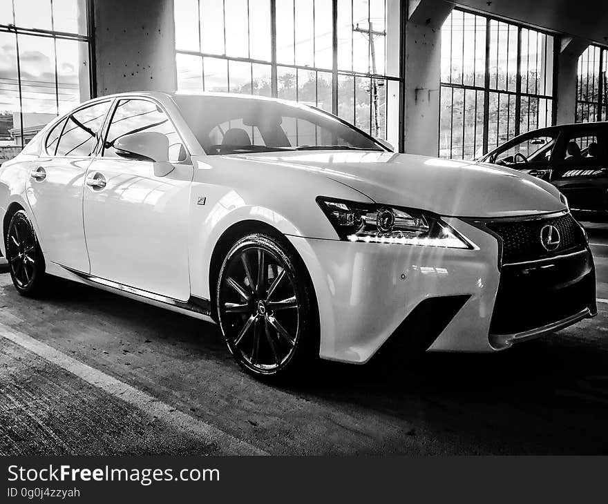 A black and white photo of a Lexus in a garage. A black and white photo of a Lexus in a garage.