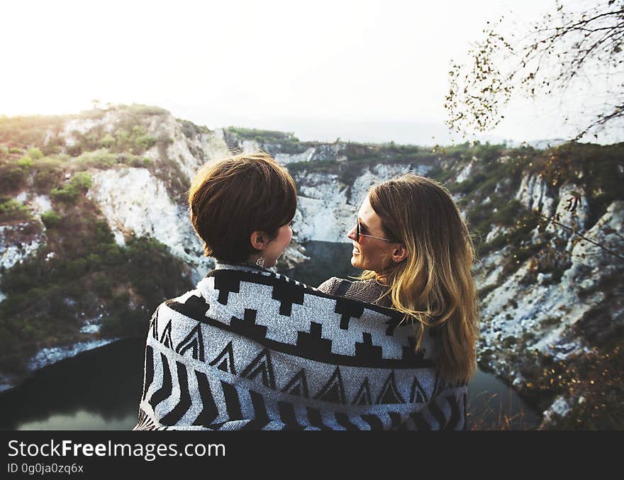 A pair of friends wrapped in a common blanket watching the mountains. A pair of friends wrapped in a common blanket watching the mountains.