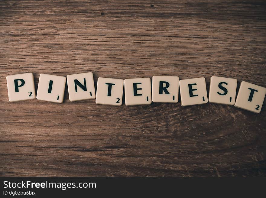 Letter blocks with the word "Pinterest" on a wood background.