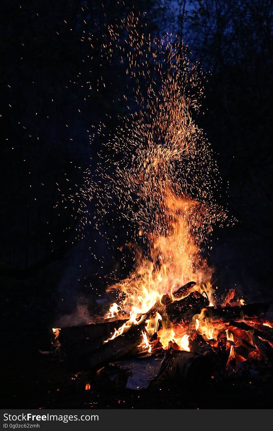 Campfire emitting sparks into the night.