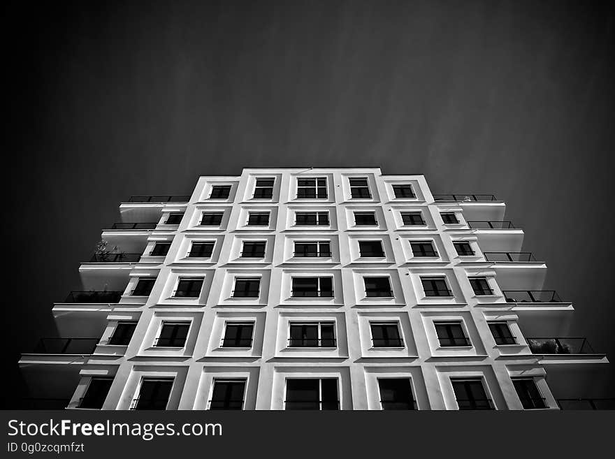 Black and white view looking towards top of modern residential tower block building. Black and white view looking towards top of modern residential tower block building.