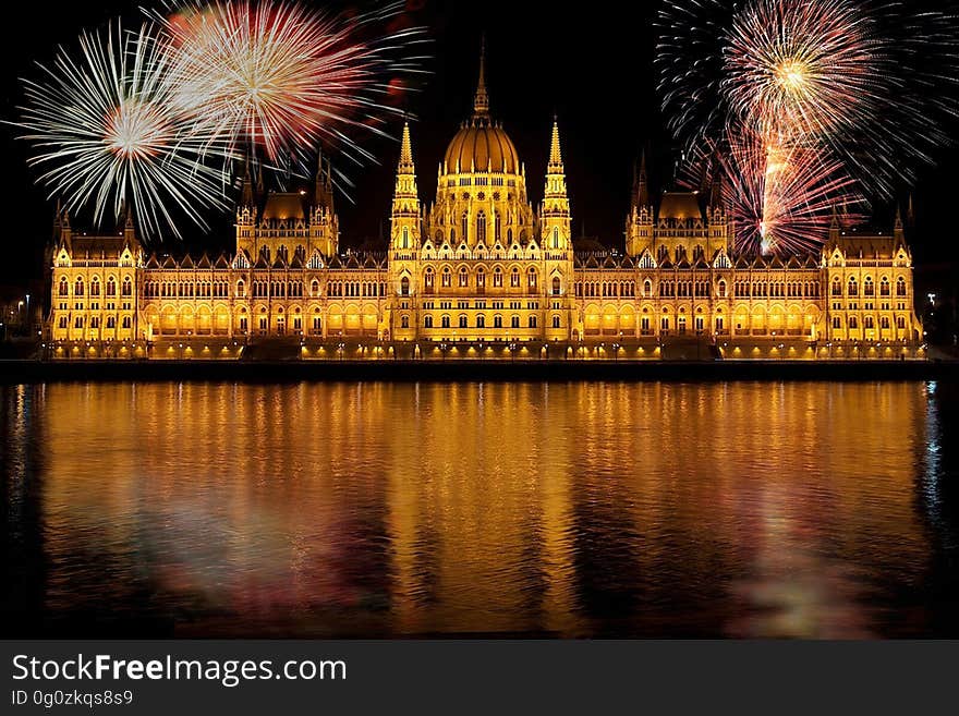 Fireworks exploding at night during News Years Eve celebration over Hungarian Parliament building with Danube river in foreground, Budapest, Hungary. Fireworks exploding at night during News Years Eve celebration over Hungarian Parliament building with Danube river in foreground, Budapest, Hungary.