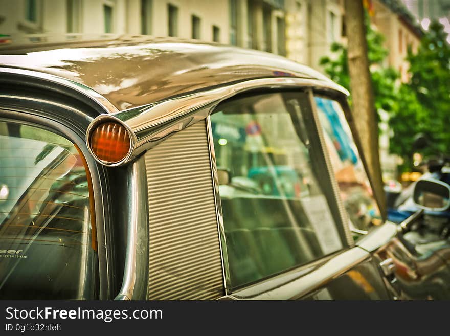 Silver Car Travelling Near White Concrete Building during Daytime Close Up Photo