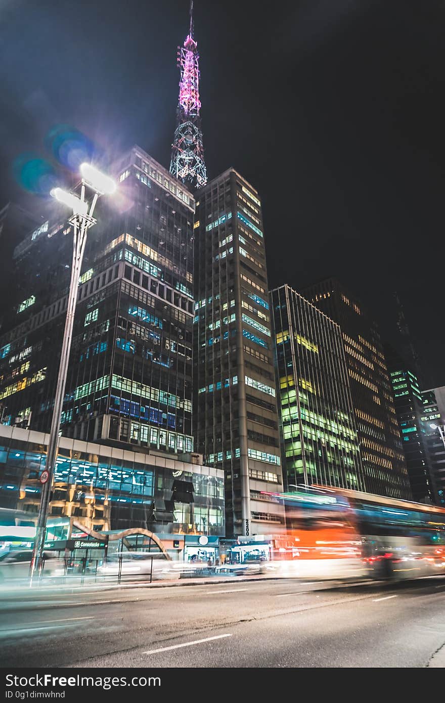 A view from a city with modern skyscrapers with lights and busy street with traffic.